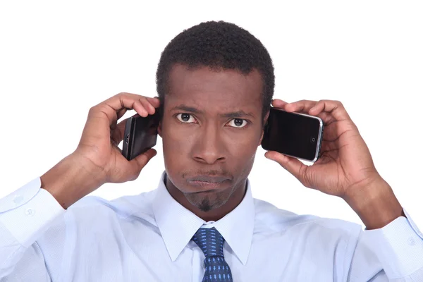 Человек с двумя телефонами — стоковое фото