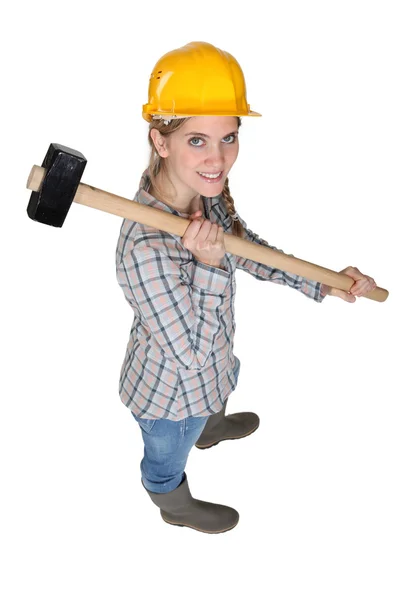 A female construction worker with a sledgehammer. Stock Photo