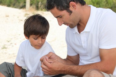 Father teaching son how to fish clipart