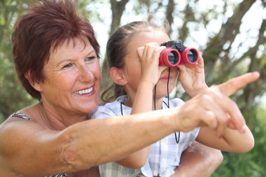 Grandmother with granddaughter and binoculars clipart