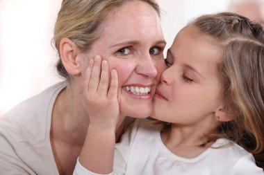 Little girl kissing woman clipart