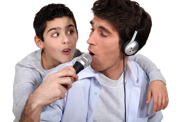 Pai e filho ouvindo música e cantando — Fotografia de Stock