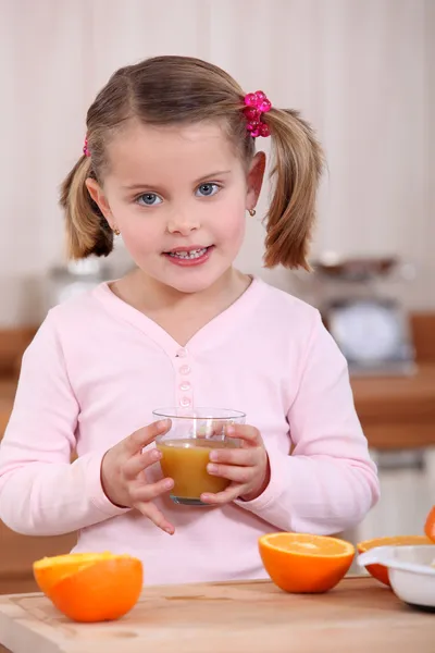 Девушка пьет апельсиновый сок — стоковое фото