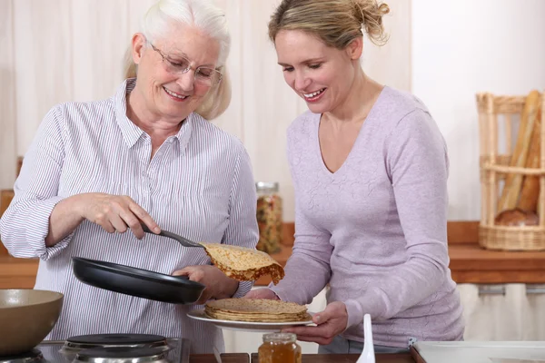 老年妇女和女儿吃煎饼 — 图库照片