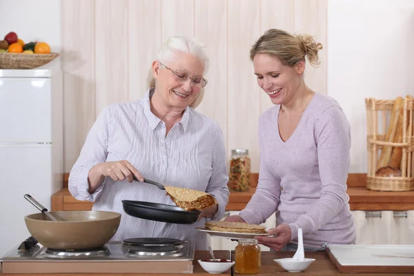 Moeder en dochter koken pannenkoeken — Stockfoto