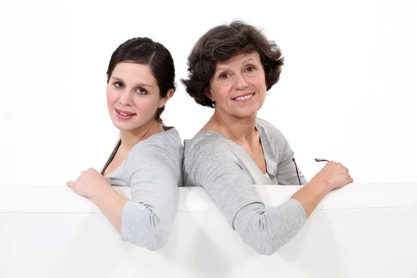 Twee vrouwen zitten in een bank — Stockfoto
