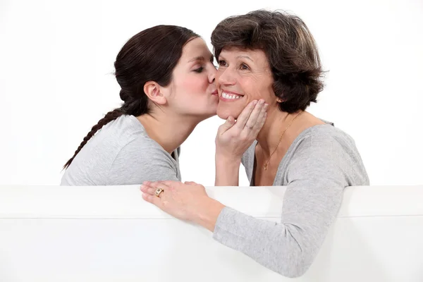 Daughter giving her mother a kiss on the cheek — Stock Photo, Image