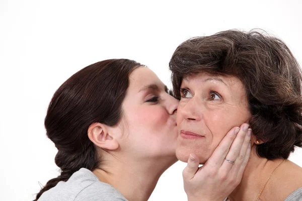 Дочь целует мать — стоковое фото