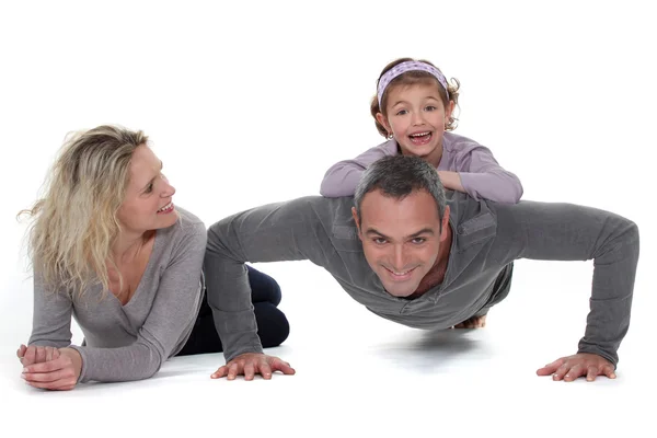 Padre haciendo flexiones con su hija en la espalda — Foto de Stock