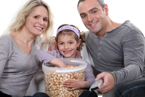 Familie isst Popcorn vor dem Fernseher — Stockfoto