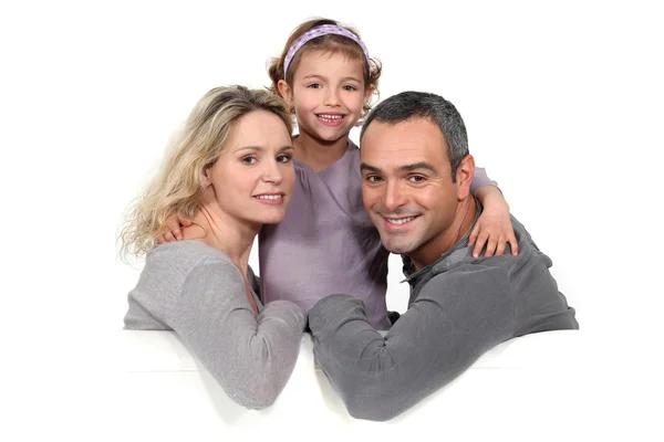 Portrait of couple with daughter against studio background — Stock Photo, Image