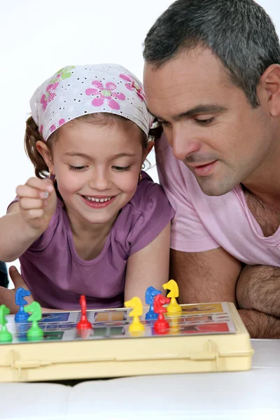 Bambina che gioca a un gioco da tavolo con l'uomo — Foto Stock