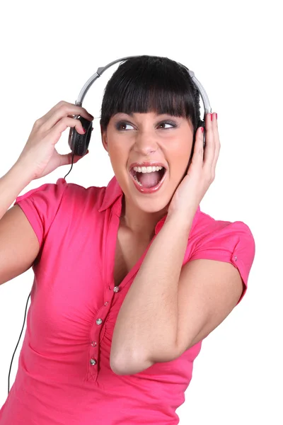 Brunette luisteren naar luide muziek via de koptelefoon — Stockfoto