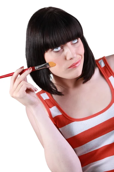 Mujer atractiva que pone en la fundación con un cepillo —  Fotos de Stock