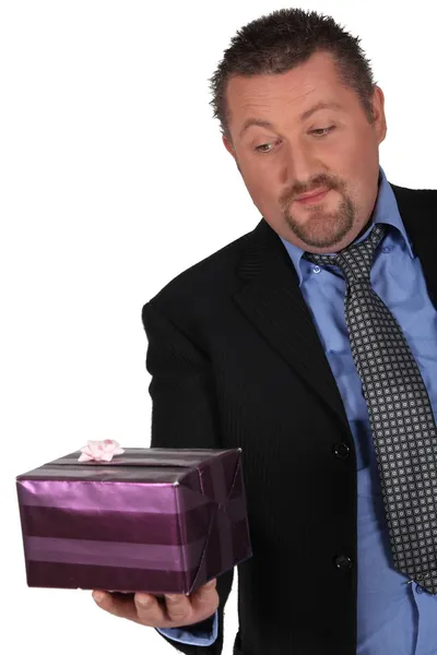 Geschäftsmann mit verpacktem Geschenk — Stockfoto