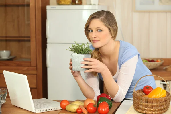 Žena vonící bylinky v kuchyni — Stock fotografie