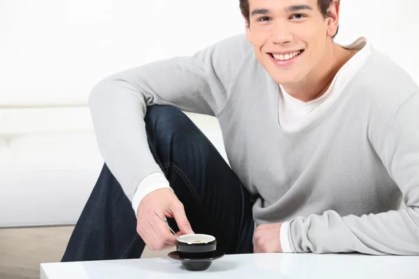 Fiatal férfi iszik egy csésze kávét — Stock Fotó