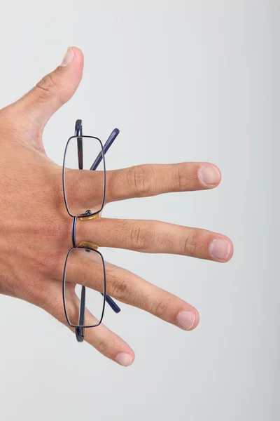 Mão segurando óculos dobrados — Fotografia de Stock