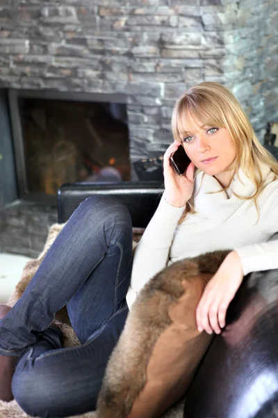 Blondýnka seděla při volání na pohovce — Stock fotografie