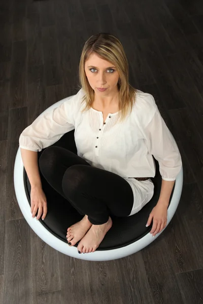 Frau saß barfuß im Designerstuhl — Stockfoto