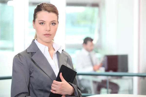 Affärskvinna poserar med mappen på jobbet — Stockfoto