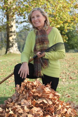 Landscape picture of woman picking up litter clipart