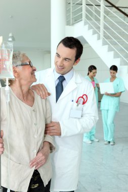 Doctor with senior woman in hospital clipart