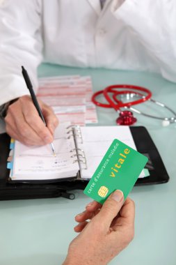 Patient handing social security card to doctor clipart