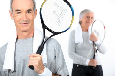 Senior couple with tennis rackets clipart