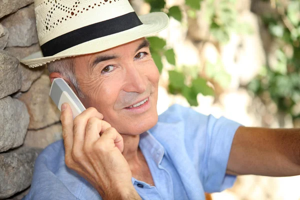 Oudere man met behulp van een mobiele telefoon in de buitenlucht — Stockfoto
