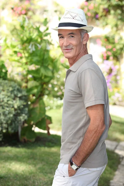 Старший мужчина прогуливается по саду — стоковое фото