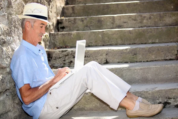 Senior gentleman working on laptop outdoors — Stock Photo, Image