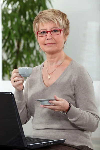コンピューターとコーヒー カップを持つ女性 — ストック写真