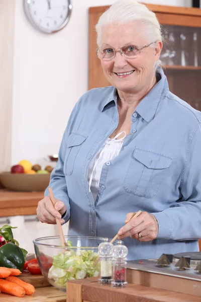 Senior woman preparing salad — Stock Photo, Image