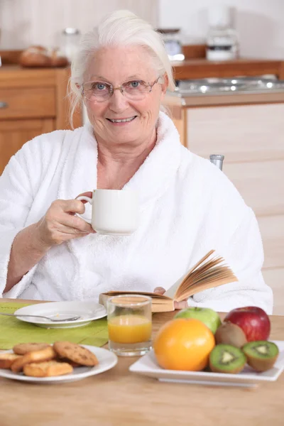 Senior woman having a relaxed breakfast — Stock Photo, Image