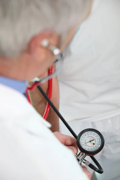 Arzt nimmt Blutdruck des Patienten — Stockfoto