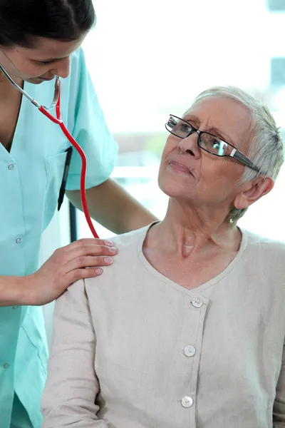 Enfermera tomando la frecuencia cardíaca del paciente — Foto de Stock