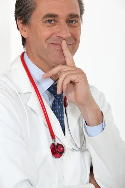 Мужчина-врач держит палец у рта — стоковое фото