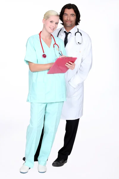 Врач и медсестра стояли с результатами пациентов — стоковое фото