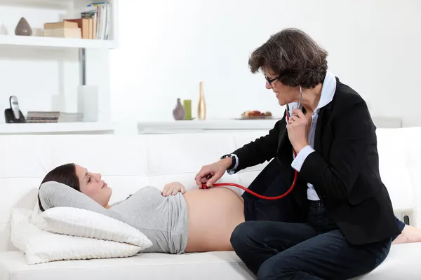 Pregnant woman having a doctor examine her — Stok fotoğraf