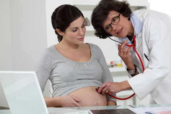 Lekarz sprawdzanie kobieta w ciąży brzuch — Zdjęcie stockowe