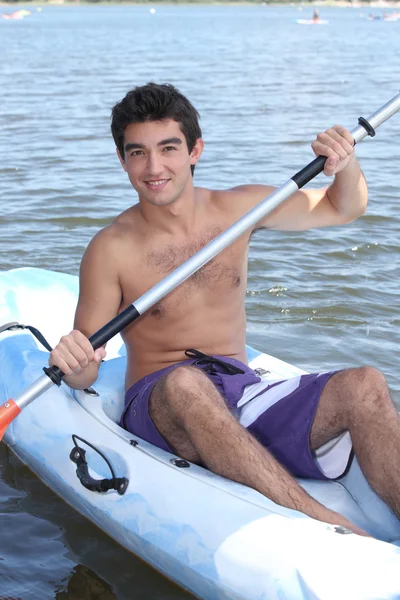 Rapaz remando em canoa — Fotografia de Stock