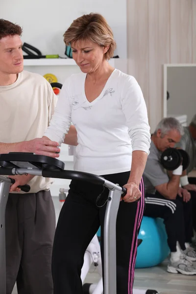 Kvinna med en coach i gymmet — Stockfoto