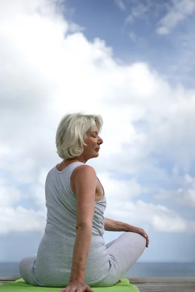 Femme âgée faisant du yoga en plein air — Photo