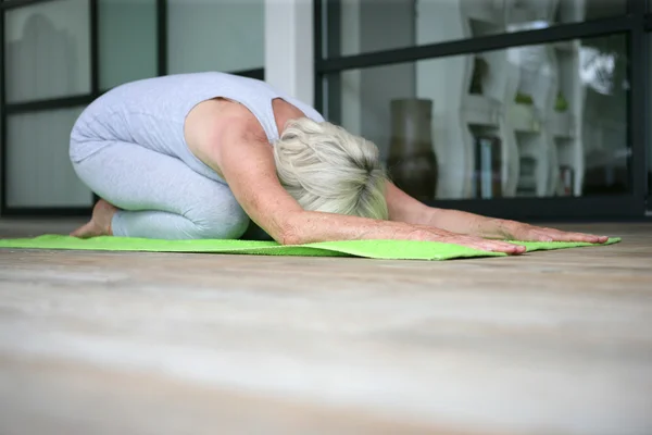 Medelålders kvinna som gör yoga — Stockfoto