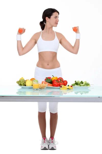 Woman with dumbbells and healthy food — Stockfoto