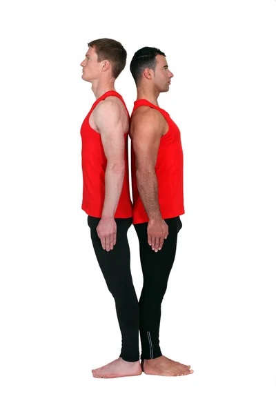 Гимнасты-мужчины стояли спиной к спине — стоковое фото