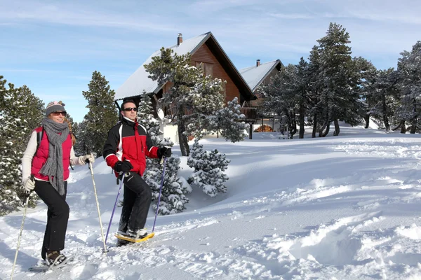 Paar wandelen in sneeuwschoenen — Stockfoto