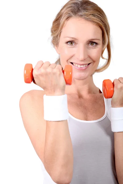 Woman with orange weights Royalty Free Stock Photos