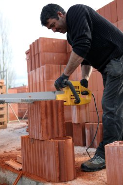 A workman using a chainsaw clipart